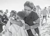  ?? ?? Mathealine Lewis wraps up her son, Whitley Edward, in a towel after he and his sister were baptized in the Atlantic.