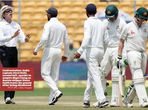  ?? PICTURE: Getty Images ?? Confrontat­ion: India captain Virat Kohl, second left, speaks to umpire Nigel Llong as Aussie skipper Steve Smith leaves the ground after being dismissed