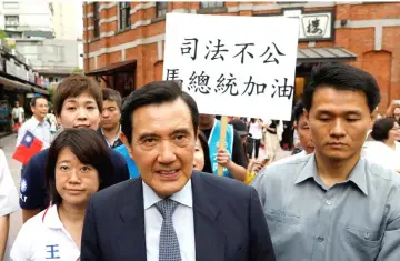  ??  ?? Members of the Kuomintang hold a placard reading, ‘Injustice, President Ma Cheer Up’, as Ma (second right) leaves from an event in Taipei. — Reuters photo