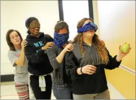  ?? MICHILEA PATTERSON — DIGITAL FIRST MEDIA ?? Girls wear blindfolds while doing a team exercise which involved putting balls in a bucket during an all-girl health and wellness summit at the Montgomery County Community College campus in Pottstown.