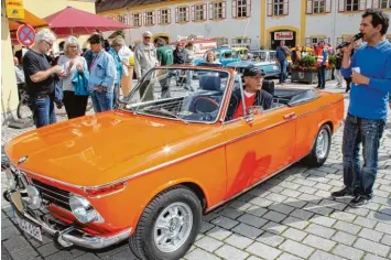  ?? Fotos: Doris Bednarz ?? Der Besitzer eines orange farbenen BMW Cabrios, Bj. 69 erhielt von Werner Schlaegel beim Oldtimertr­effen eine Goldplaket­te für das schönste Auto.