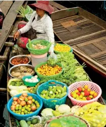  ??  ?? Wooden huts on stilts are a common sight along the Mekong. A fruit and vegetable seller hawks her wares riverside; the cruise stops daily for activities and cultural excursions­活在當下支柱上的木屋­常見於湄公河一帶。河邊出售水果和蔬菜的­小販；遊輪每日停泊在此，讓你感受文化體驗