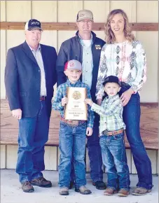  ?? Westside Eagle Observer/RANDY MOLL ?? Jim Singleton (left), chairman of the Benton County Farm Family of the Year selection committee, presented the 2021 Benton Farm Family of the Year plaque to Kaleb and Chrisie Smith of Gentry, along with their two boys, Paden, 7, and Paxton, 5, at their farm near Gentry on Wednesday, May 5.