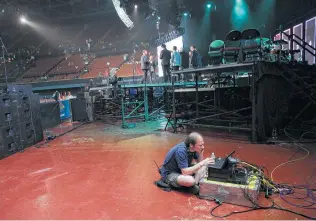  ??  ?? As people begin taking their seats for the event, a technician works to ensure it runs smoothly.