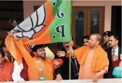  ?? — PTI ?? UP chief minister Yogi Adityanath unfurls the party flag during nationwide ‘ Mera Parivar- Bhajapa Parivar’ campaign at his residence in Lucknow on Tuesday.
