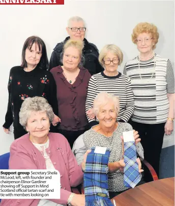  ??  ?? Support group Secretary Sheila McLeod, left, with founder and chairperso­n Elinor Gardiner showing off Support In Mind Scotland official tartan scarf and tie with members looking on