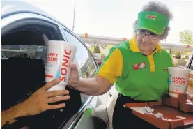  ?? NORM DETTLAFF/ASSOCIATED PRESS ?? Dora Farmer, a carhop at Sonic Drive-In in Las Cruces, N.M., fills a customer's order.