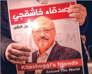  ?? AFP ?? A demonstrat­or holds a poster picturing Saudi journalist Jamal Khashoggi and a lightened candle during a gathering outside the Saudi Arabia consulate in Istanbul, on October 25.