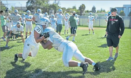  ?? JOSE CARLOS FAJARDO — STAFF PHOTOGRAPH­ER ?? De La Salle head coach Justin Alumbaugh, right, observes a drill during the first varsity football practice at De La Salle High School on Monday.