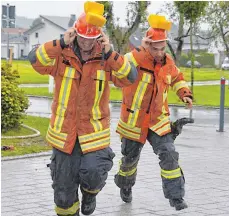  ?? FOTO: KLAUS WEISS ?? Wasserspie­le bei strömendem Regen: Mit Schwämmen wird das Wasser auf dem Kopf transporti­ert.