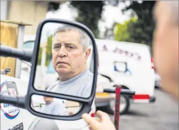  ?? Stuart Palley For The Times ?? ROBERT BOWMAN, 65, is ref lected in the mirror of a tow truck at George & Joey’s Towing in Torrance, where he worked for 13 years. He says he might have signed up late for Medicare Part B if not for a friend’s tip.