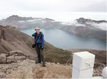  ??  ?? Tarjei Naess Skrede of Norway, trekking with Roger Shepherd of Hike Korea, gets in a view of the caldera and Lake Chon on Mount Paektu in North Korea. It’s a scene rarely witnessed by outsiders.