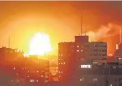  ?? Mahmud Hams / AFP / Getty Images ?? A ball of fire rises above the building that houses the Hamas-run television station Al-Aqsa in the Gaza Strip during an Israeli airstrike on Monday.