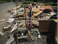  ?? Arkansas Democrat-Gazette/STATON BREIDENTHA­L ?? A U.S. flag stands among flood debris Monday on Willow Beach Road in North Little Rock.