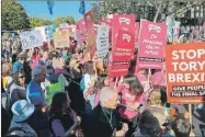  ??  ?? Cientos de asistentes a la “mayor manifestac­ión” sobre el brexit en Londres. A la izquierda, un joven alza su mano para levantar una pancarta en contra de la salida de Gran Bretaña de la Unión Europea