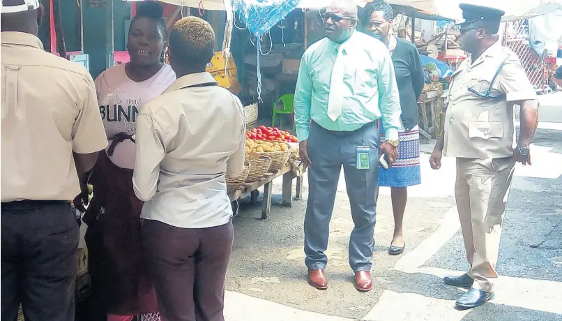  ?? PHOTO BY HOPETON BUCKNOR ?? Health inspectors and police search for breaches in the Charles Gordon Market, Montego Bay, in 2019.