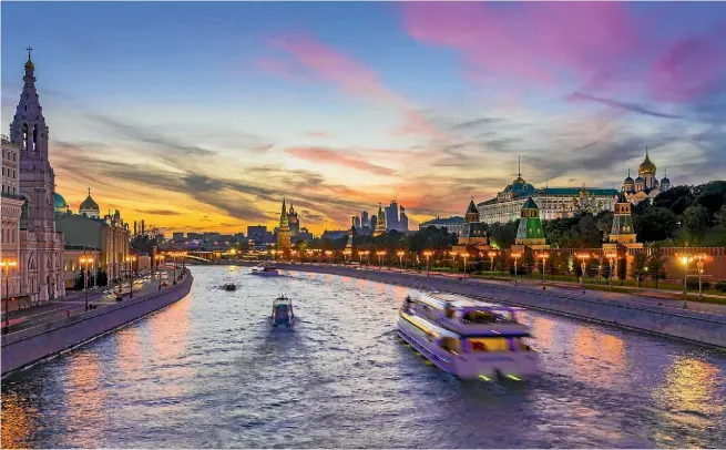  ??  ?? The Moskva River flows past the Kremlin in Moscow at sunset.