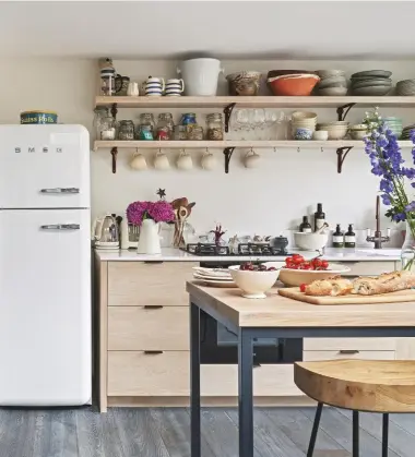  ??  ?? KITCHEN
Metal-framed doors lend an industrial look, while pale wood adds a Scandi feel. Strong Boy cast-iron shelf brackets, £37.50 each, Mark Lewis Interior Design. Crittall Doors, price on request, Perla Windows. Counter stools, £190 each, Cox & Cox. Try the Tubby two-seater sofa in Saffron Yellow velvet, £349, Made. Baco swing-arm wall light, £545, Julian Chichester