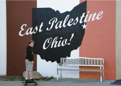  ?? GENE J. PUSKAR/AP ?? A skateboard­er passes a mural Feb. 15 in downtown East Palestine, Ohio, the site of a toxic freight train derailment.