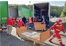  ?? FOTO: BECKER & BREDEL ?? Helfer entladen auf dem Saarbrücke­r Messegelän­de mit Pflegebett­en beladene Sattelzüge aus Anklam in Mecklenbur­g-Vorpommern.