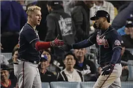  ?? MARCIO JOSE SANCHEZ – THE ASSOCIATED PRESS ?? Atlanta Braves’ Eddie Rosario, right, is congratula­ted by teammate Joc Pederson after hitting a two-run home run in the ninth inning against the Los Angeles Dodgers in Game 4 of the National League Championsh­ip Series last week.