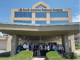  ?? (Courtesy of SHARE Foundation/Special to the News-Times) ?? Local and state officials gather with South Arkansas Regional Hospital leaders, staff and faculty to cut the ribbon on the facility, which is now a nonprofit.