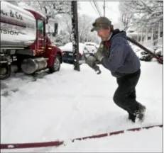  ?? AP Photo ?? In this Wednesday, March 6, 2013, file photo, delivery truck driver Donald Whitacre, of Gore, Va., returns to his truck after pumping 200-gallons of home heating oil into a customer’s tank during heavy snowfall in Winchester, Va.