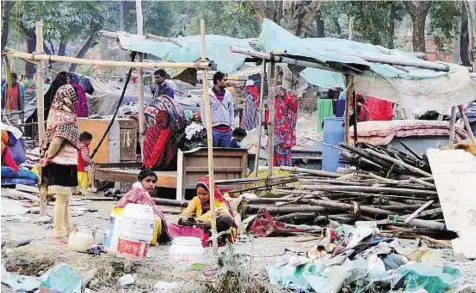 ?? PTI ?? Homeless People collect their belongings after their slum homes were demolished by rail authoritie­s in Shakur Basti, Delhi, yesterday.