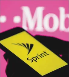  ?? — Reuters ?? A smartphone with Sprint logo are seen in front of a screen projection of T-mobile logo, in this picture illustrati­on.