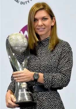  ??  ?? Simona Halep (above) of Romania poses with her WTA year-end world number one trophy at the WTA Finals tennis tournament in Singapore on Sunday. Below: WTA chief executive officer Steve Simon presents a gift to Switzerlan­d’s Martina Hingis on her...