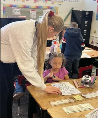  ?? PHOTO PROVIDED BY JEN KRAL — SPECIAL TO THE TIMES ?? A teacher going through the Teach Today Alternativ­e Licensure program helps one of her students. The program provides a new method to get teachers into classrooms and can provide a new career path for people.