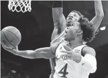  ?? Ed Zurga Getty Images ?? THE JAYHAWKS’ Devonte’ Graham drives to the basket during Saturday’s game against Texas. He finished with 18 points.