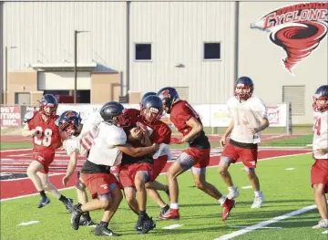  ?? PHOTOS BY DWAIN HEBDA/CONTRIBUTI­NG PHOTOGRAPH­ER ?? Carrying the ball, sophomore Cayden Rose is tackled by sophomore Darrian Thomas during a summer workout at Russellvil­le’s Cyclone Stadium.