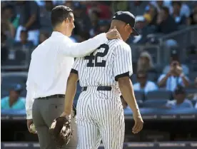  ??  ?? JORGE POSADA, otrora receptor yankee, escolta a su excompañer­o de batería hacia el dugout al concluir la actividad.