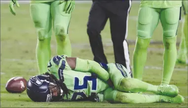  ?? The Associated Press ?? Seattle Seahawks cornerback Richard Sherman lies injured on the turf after tackling Arizona Cardinals receiver John Brown during second-half NFL action on Thursday night in Glendale, Ariz. Sherman ruptured his Achilles in Seattle’s 22-16 win.