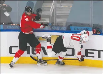  ?? CP PHOTO JASON FRANSON ?? Canada’s Quinton Byfield (19) checks Switzerlan­d’s Elvis Schlaepfer (10) during third period IIHF World Junior Hockey Championsh­ip action in Edmonton on Tuesday.