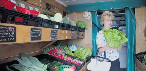  ??  ?? Une cliente sélectionn­e sa laitue dans la Caravane.