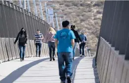  ?? GREGORY BULL/AP ?? Pedestrian­s make their way Wednesday across the bridge that connects Tijuana, Mexico, to the United States at the San Ysidro Port of Entry in San Diego, California.
