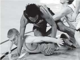  ?? MARK ZALESKI/FOR THE TENNESSEAN ?? Clay County guard Eli Smith scrambles for a loose ball with MAHS forward Dylan Woods on Saturday.