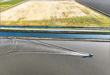  ?? Robert Gauthier Los Angeles Times ?? A BOAT skims across Tulare Lake, which reappeared on farmland last year but has since receded. Large agricultur­al landowners in the lake basin must start reporting to California how much water they pump.