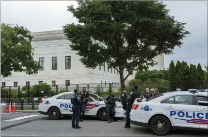  ?? GEMUNU AMARASINGH­E — THE ASSOCIATED PRESS ?? Police officers outside U.S. Supreme Court on Thursday. Justices ruled that against a New York law requiring people to carry a gun in public to get a license.