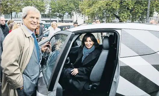  ?? PATRICK KOVARIK / AFP ?? Pioneros
Vincent Bolloré, presidente del grupo Bolloré, y Anne Hidalgo, alcaldesa de París, en el 2014 con un nuevo coche Autolib