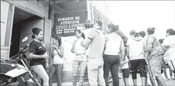  ??  ?? People line up outside the Centro Piloto office seeking informatio­n about school enrollment for undocument­ed Venezuelan children in Cúcuta, Colombia on April 4, 2018.