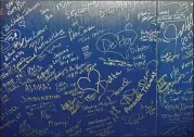  ?? HYOSUB SHIN / HSHIN@AJC.COM ?? Former and current employees of Delta Air Lines write on the exterior of a Delta 747 during a 747 hangar party Tuesday at Delta TechOps.