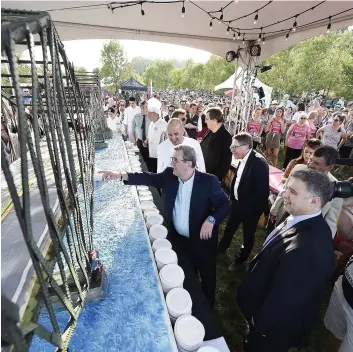  ?? PHOTO LE JOURNAL DE QUÉBEC, DANIEL MALLARD ?? Le maire Régis Labeaume et son homologue de Lévis, Gilles Lehouillie­r, ont participé au découpage du gâteau cuisiné pour célébrer le centenaire du pont, hier.