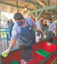  ??  ?? Employees disinfect a train at Adventure City.