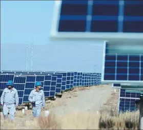  ?? XINHUA ?? Technician­s inspect solar power facilities in Gonghe county, Hainan Tibetan autonomous prefecture,Qinghai province.