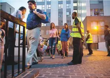  ?? AP ?? Above: Residents are evacuated from the Taplow residentia­l tower block on the Chalcots Estate, in the borough of Camden, north London, Friday. A local London council has decided to evacuate some 800 households in apartment buildings it owns because of...