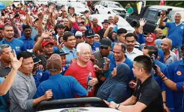  ??  ?? Enthusiast­ic welcome: Najib being mobbed by supporters at the morning market.