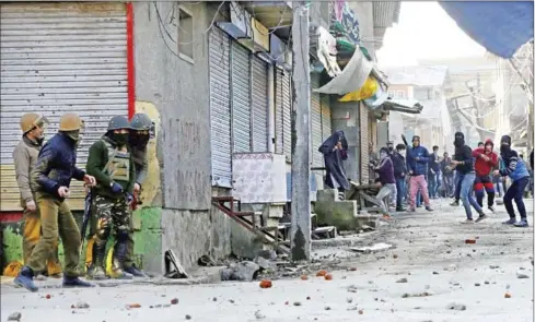 ?? AFP ?? Masked Indian Kashmiri protesters (right) throw stones towards Indian government forces during clashes after Friday congregati­on prayers against Indian rule outside the grand mosque Jamia Masjid in downtown Srinagar on February 9.
